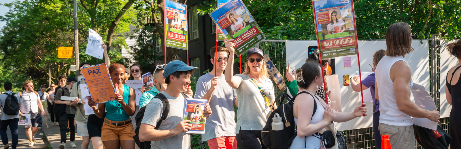 Fringe artists parade on the street holding posters and cheering