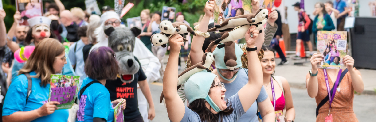 Fringe artists parade on the street holding posters and cheering