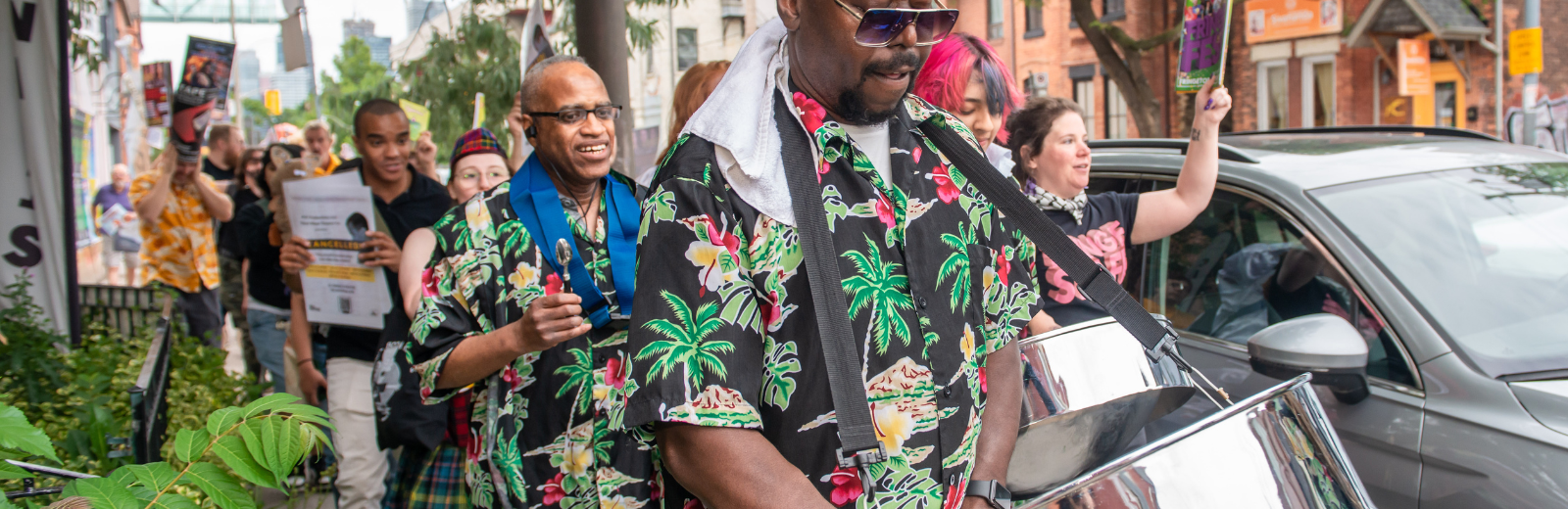 Steel pan players walk in the Fringe artist parade
