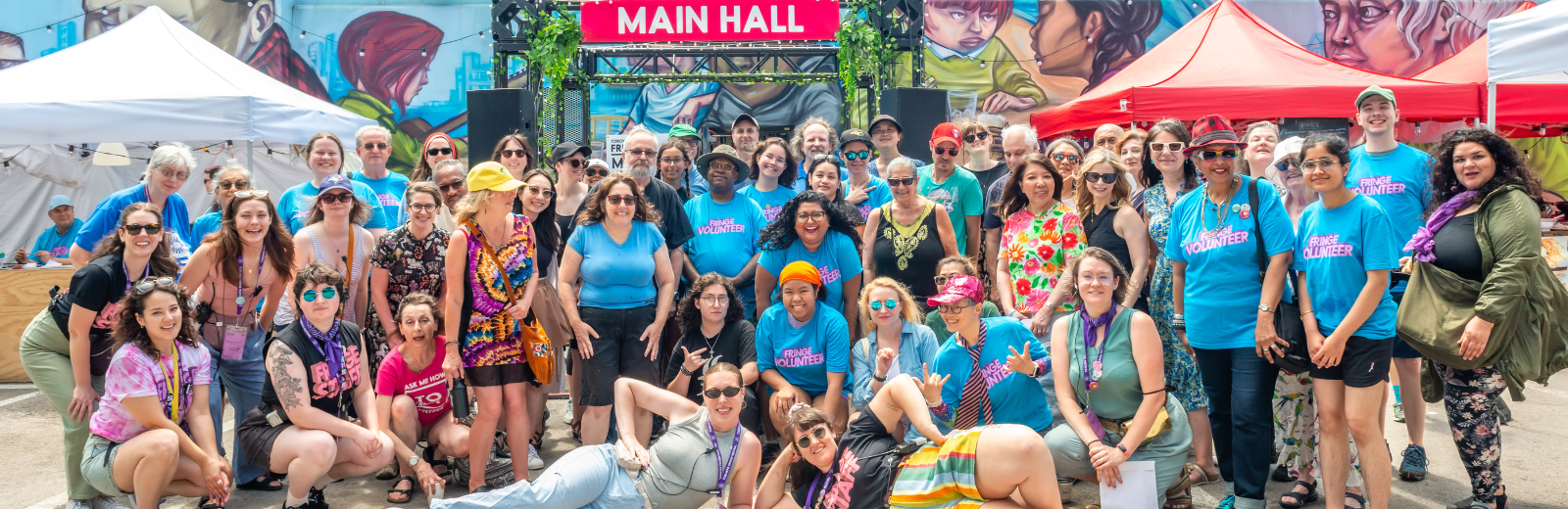 Fringe 2024 volunteers pose with a big photo at the Fringe patio