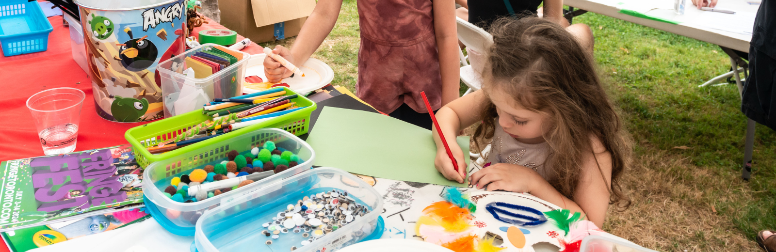 A kid colours and crafts at the KidsFest Club